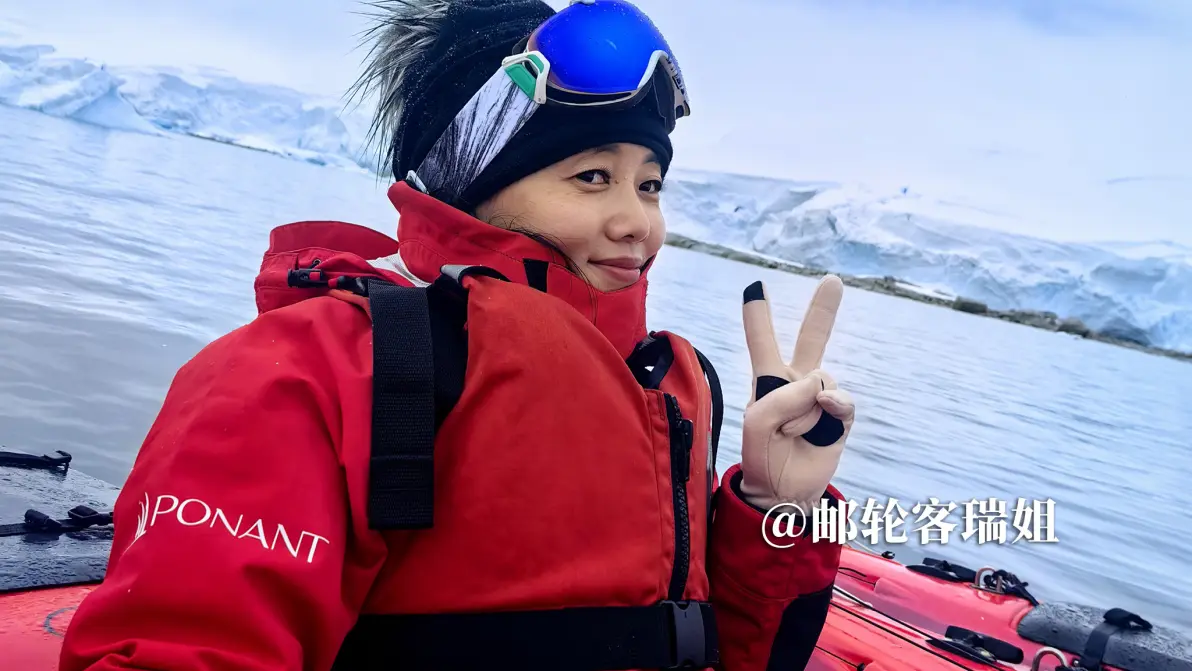 瑞姐在冲锋艇上回头微笑,身后是南极雪山