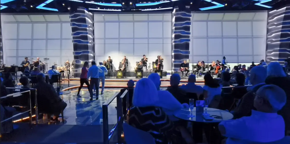 旅客坐在船上的休息区观看现场音乐演出