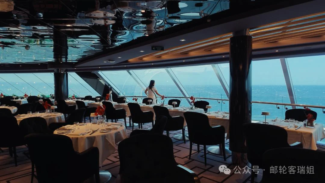 邮轮观景休息区内的座位、钢琴和面向海面的落地窗