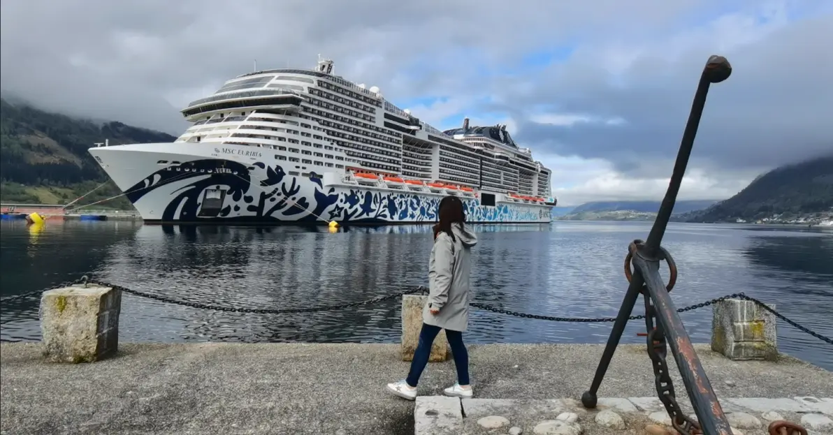 瑞姐在峡湾码头，身后停靠 MSC Euribia 邮轮